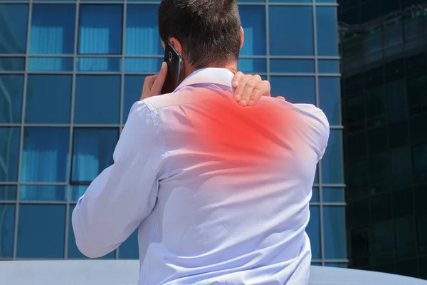 Man with back pain. Business man rubbing his painful neck