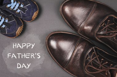 Babalar günü kutlu kart tasarımı kutlu olsun. Büyük baba ayakkabı ve bebek çocuk, vintage görüntü küçük ayakkabı