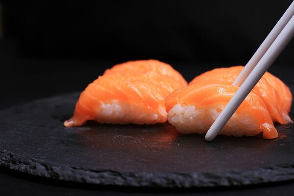 Salmon Nigiri Sushi on black background.