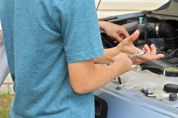 Un chico ayudando a papá a reparar el coche. Concepto familiar — Foto de Stock