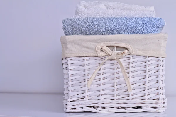 깨끗 한 세탁입니다. 고리 버들 세공 바구니에 다양 한 색상의 부드러운 목욕 수건 — 스톡 사진