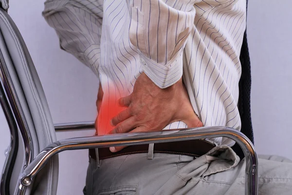 Hombre de negocios con dolor de espalda sentado en una silla de oficina. Dolor — Foto de Stock