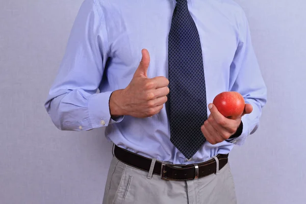 Επιχειρηματίας κρατώντας apple και δείχνει τους αντίχειρες επάνω. Υγιείς διατροφικές έννοια — Φωτογραφία Αρχείου