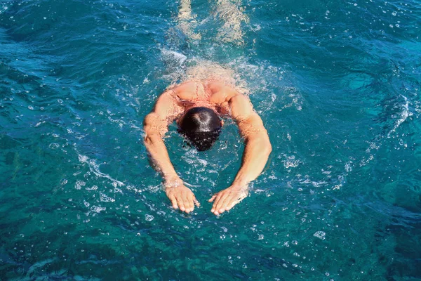 Strong athletic man swimming butterfly style in the sea. Active summer holiday vacation. Sport, healthy lifestyle concept — Stock Photo, Image