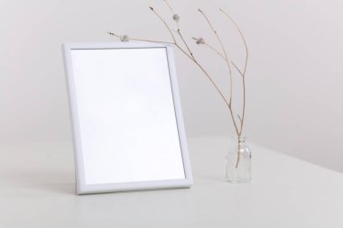 Boş resim çerçevesi ve kuru çiçekli vazo. Minimalist stil ev dekorasyonu. Basit ve zarif bir tasarım. Boşluk resmini kopyala.