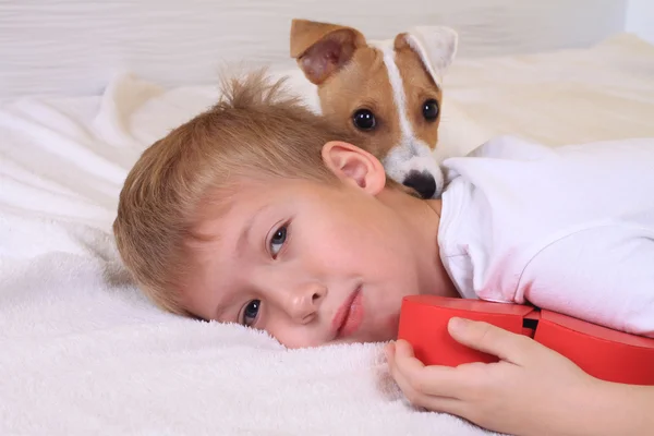Młody chłopak przytulanie jego pies w łóżku — Zdjęcie stockowe