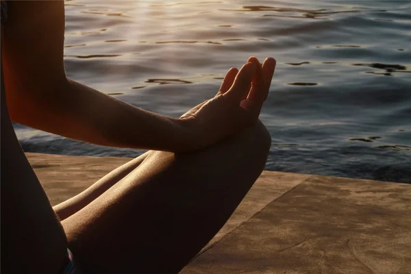 Main de femme méditant dans une pose de yoga sur la plage — Photo