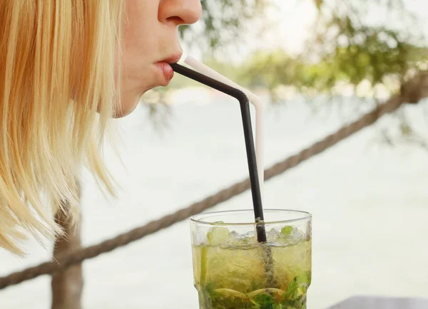 Retrato de cerca de una joven disfrutando de un cóctel mojito — Foto de Stock