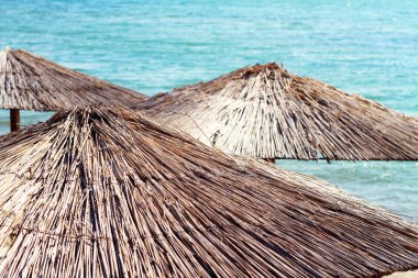 Straw Beach Umbrellas against blue sea,ocean. Summer, holiday, vacation background