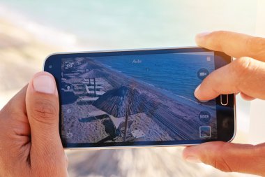 Yalı mobil cep telefonu ile fotoğraf çekici erkek ellerinde kapatın. Yaz plaj tatil tatil kavramı
