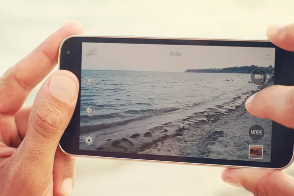 Închideți mâinile de sex masculin care fotografiază coasta mării cu telefonul mobil. Summer Beach concediu concediu concept — Fotografie, imagine de stoc