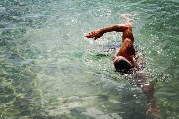 Strong muscular man swimming in the sea ocean srawl style. Active summer holiday vacation. Sport, healthy lifestyle concept — Stock Photo, Image