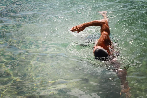 Strong muscular man swimming in the sea ocean srawl style. Active summer holiday vacation. Sport, healthy lifestyle concept — Stock Photo, Image