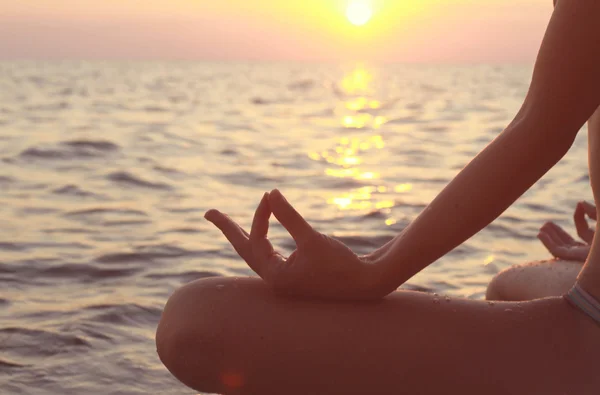 Clope się w rękach kobiet medytacji w pozycji jogi na plaży — Zdjęcie stockowe