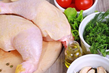 Çiğ tavuk budu salata, zeytin yağı ve ahşap kesme tahtası üzerinde kiraz domates ile dekore edilmiştir. Diyet gıda, sağlıklı yaşam tarzı
