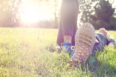 Female athlete resting and relaxing after workout. Woman lying down on grass. Healthy lifestyle and happiness concept