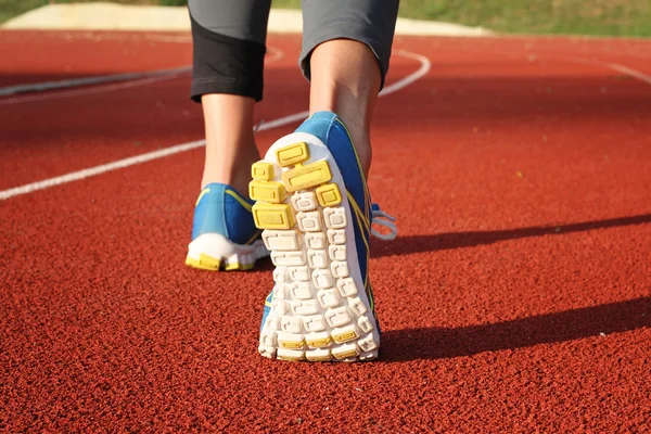 运动员赛跑者脚下来体育场跑道。在女性的鞋子和腿的特写。女人秋天的健身锻炼。慢跑，运动，健康积极的生活方式的概念. — 图库照片