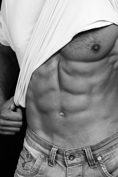 Muscular Men, perfect body, abs, six pack. Strong athletic guy in jeans showing his abs. Bodybuilding, sport, fitness ,workout, active lifestyle concept. Black and white photo — Stok fotoğraf