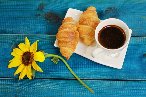 Café, croissants y girasol sobre fondo azul rústico de madera. Otoño, concepto de desayuno de vacaciones —  Fotos de Stock