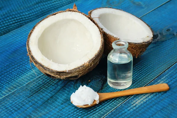 Кокосовое масло и кокосовое масло на голубом деревенском фоне — стоковое фото