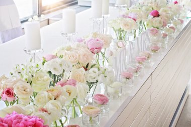 Wedding table decoration.  Ranunculus, roses, candels clipart