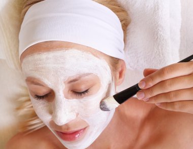 Young beautiful girl applying homemade facial mask i at home.Skin care, beauty treatments.