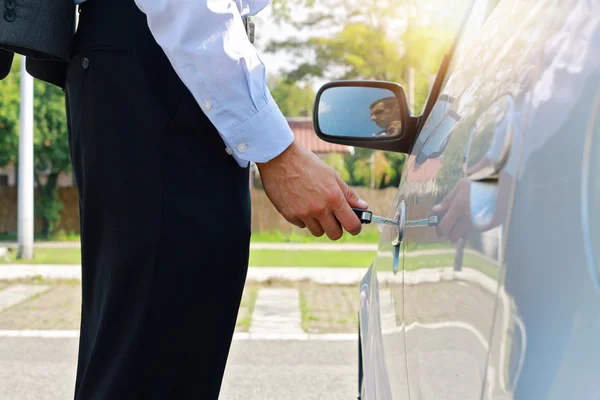 Close up of businessman in suit opening car door with key — Stok fotoğraf