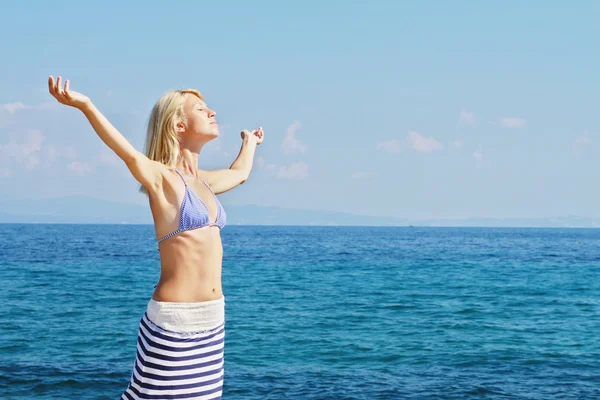 Attrayant blonde femme respirant heureux avec les bras levés, concept de liberté, mer, soleil, été, jour férié, vacances . — Photo