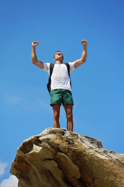 Young man with standing with raised hands on top of a mountain. Winnerer and sucsess concept. — Zdjęcie stockowe