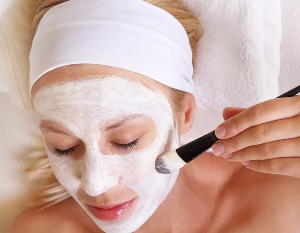 Young beautiful girl applying homemade facial mask i at home.Skin care, beauty treatments. — Stok fotoğraf