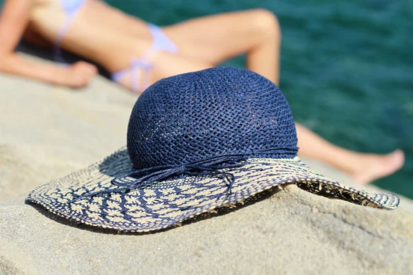 Hermosa mujer en vacaciones de verano, tumbada y tomando el sol. Sombrero de paja femenino, imagen de enfoque selectivo — Foto de Stock