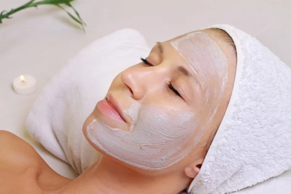 Young beautiful girl receiving clay facial mask in spa beauty sa Royalty Free Stock Images