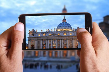Male hand taking photo of st peter basilica in Vatican with cell, mobile phone. Europe travell, Italian holiday.