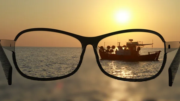 Pasang kacamata untuk tampilan yang berbeda, lebih baik. Melihat kapal di laut, laut di matahari terbenam . — Stok Foto