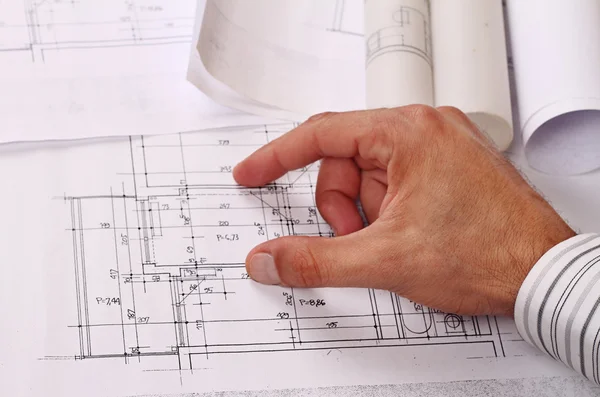 Arquitecto mostrando proyecto, planos de casa. Primer plano en la mano masculina apuntando al plan —  Fotos de Stock