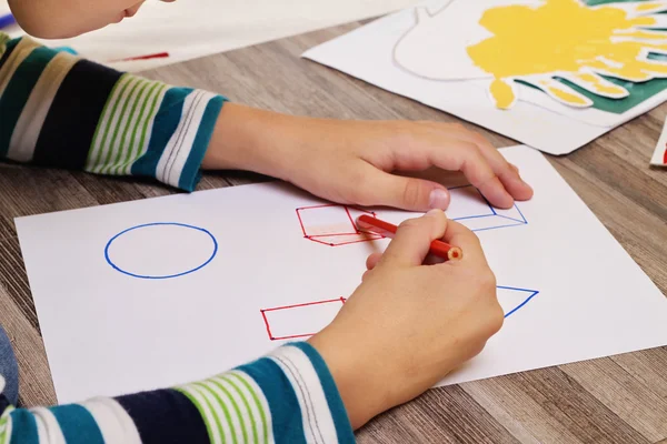 School jongen geometrische shapes tekenen op papier met potlood. Kind, huiswerk, onderwijs concept — Stockfoto