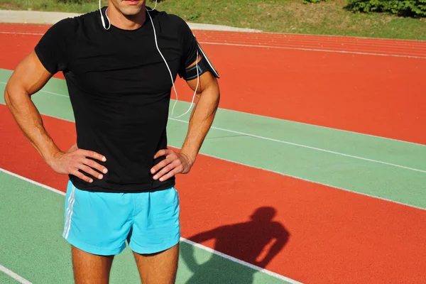 Männlicher Läufer mit Handy, der während des Trainings Musik hört. Laufen, Joggen, Cardio, Sport, aktiver Lebensstil — Stockfoto