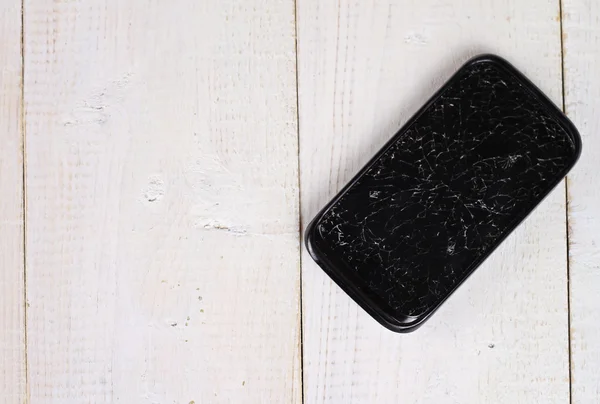 Telefon mobil negru cu ecran spart pe fundal din lemn — Fotografie, imagine de stoc