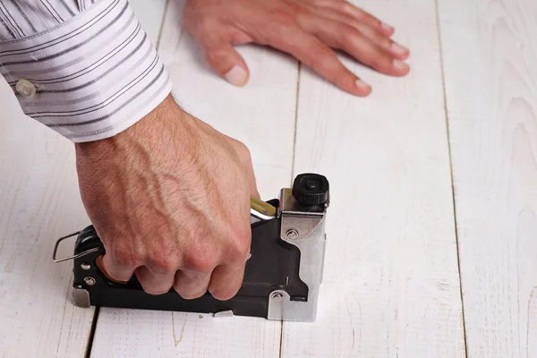 Hautnah an männlicher Hand mit einem elektrischen Nagelhammer. Mann macht Diy zu Hause — Stockfoto