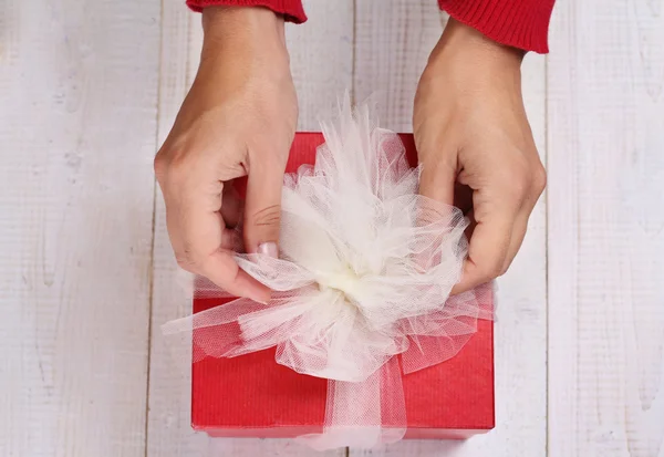 Close up on female hands holding red present with white Ribbon . Gift box packaging. Birthday, New year, Valentine's Day, 8 march, Christmas concept. — Stock Photo, Image