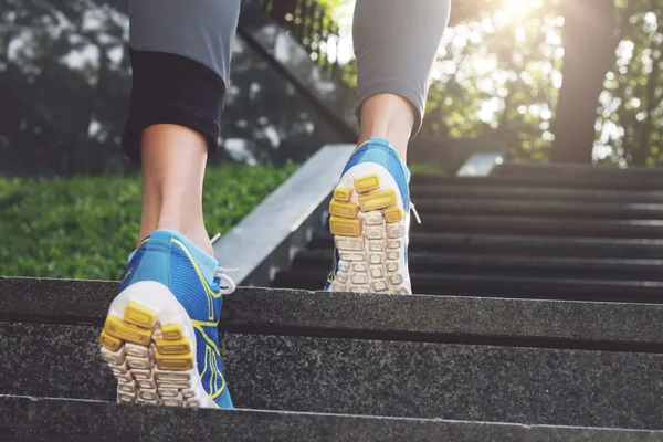 Athlète coureur pieds en cours d'exécution dans la nature, gros plan sur chaussure. Athlète féminine courant dans les escaliers. Femme fitness, course, jogging, sport, fitness, concept de mode de vie actif — Photo