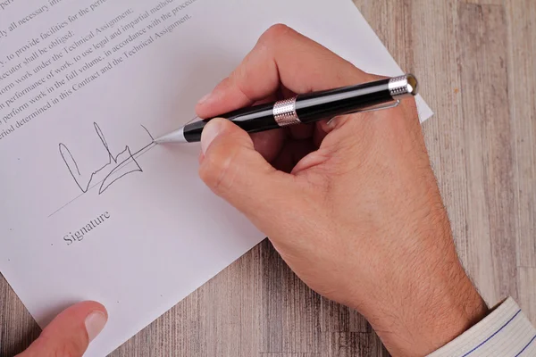 Primer plano en mano masculina poner una firma en un contrato de crédito. Primer plano del hombre de negocios firmando un contrato. Mano masculina firmando papeles. Abogado, agente inmobiliario . —  Fotos de Stock