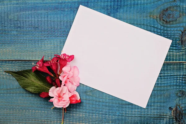 Üres üzenet-kártya és a csokor virág a kék fából készült rusztikus asztal. Szerelem, romantikus, koncepció. Másolja a helyet a háttér — Stock Fotó