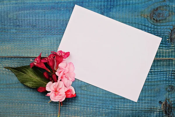 Blank message card and bouquet of flowers on blue wooden rustic table. Love, romantic, concept . Copy space background — Stock Photo, Image