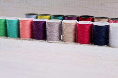 Sewing thread and accessories on white background.