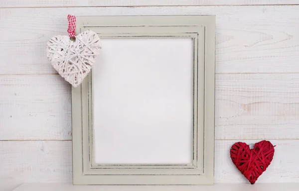 Love concept. Empty picture frame rustic , shabby chic, vintage style and heart shape decoration. Scandinavian style home interior decor. Copy space image — Stock fotografie