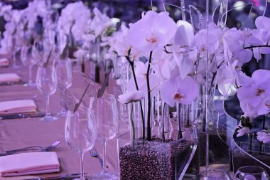 Orchid wedding decoration. White and gold colors. Wedding table for bride and groom. Glamorous Event, celebration