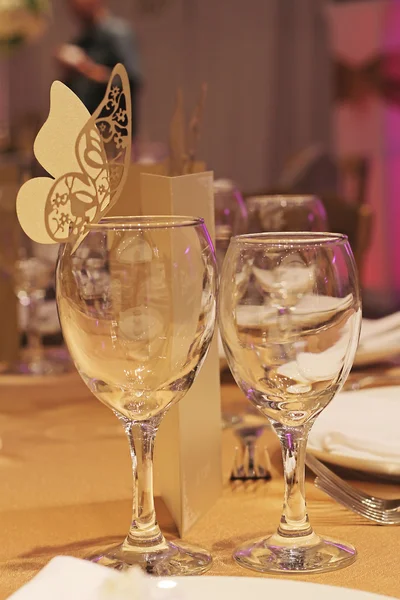 Due bicchieri di vino e decorazione a farfalla di carta. Matrimonio di Capodanno. Evento glamour, festa, Festa in oro — Foto Stock