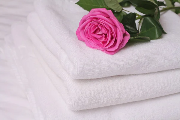 Montón de toallas de hotel blancas y suaves desacradas con flor de rosa. Perfecta ropa blanca. Concepto de luna de miel — Foto de Stock