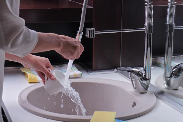 Close up of woman hands washing dishes by sponge, modern kitchen faucet and sink. Home hygiene. House cleaning and home hygiene concept — 스톡 사진